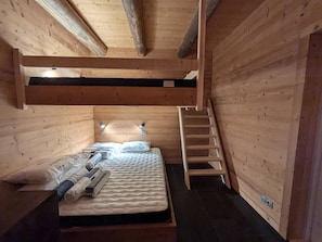 A wooden cabin room with a bunk bed, a ladder, and a small window. - Bright chalet in Arêches-Beaufort with terrace and equipped kitchen (Arêches-Beaufort)