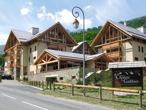 A chalet-style hotel with multiple wooden balconies and a stone facade.