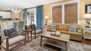 A living room with a sofa, chairs, a coffee table, and a dining area with a table and chairs.