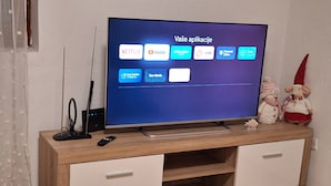 Un televisor de pantalla plana sobre un mueble de madera con dos cajones.