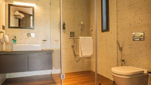 Une salle de bain moderne avec un meuble-lavabo en bois, une cabine de douche en verre et des toilettes.