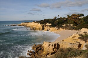 A coastal landscape with rocky cliffs, a sandy beach, and a view of the sea. - Villa 'Rústica' with Sea View, Wi-Fi and Air Conditioning (Albufeira)