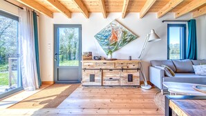 A wooden ceiling, a sofa, a cabinet, a painting, and a door.