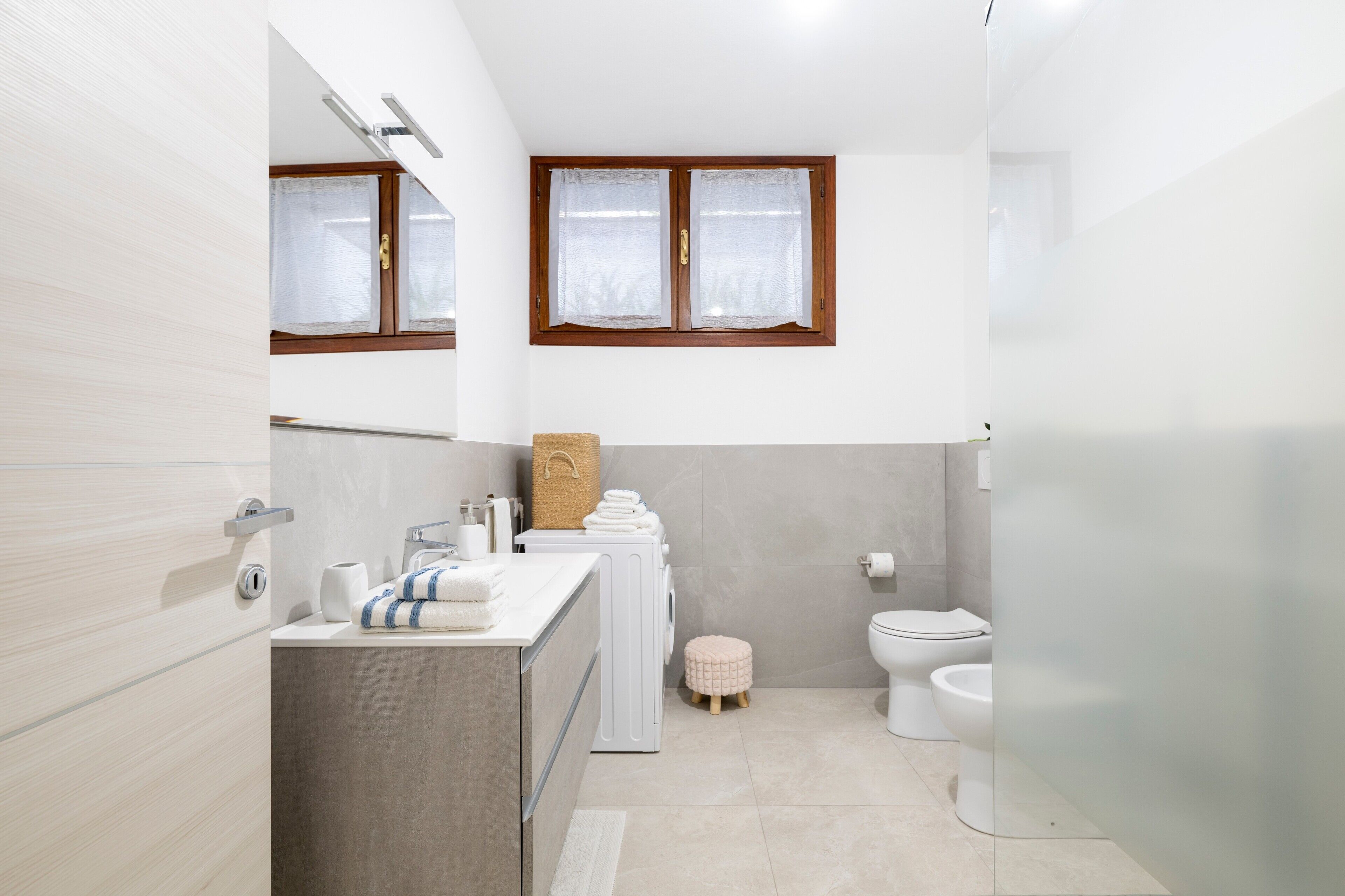 A modern bathroom with a shower, toilet, and sink.