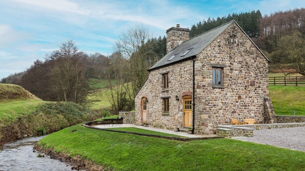 A stone house with a sloped roof, a wooden door, and a window. - Shepherd's Cottage -  a beautiful cottage sleeping 2 guests (Usk)