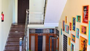 Un vestíbulo de hotel con una escalera, una recepción y una pared decorada con cuadros.