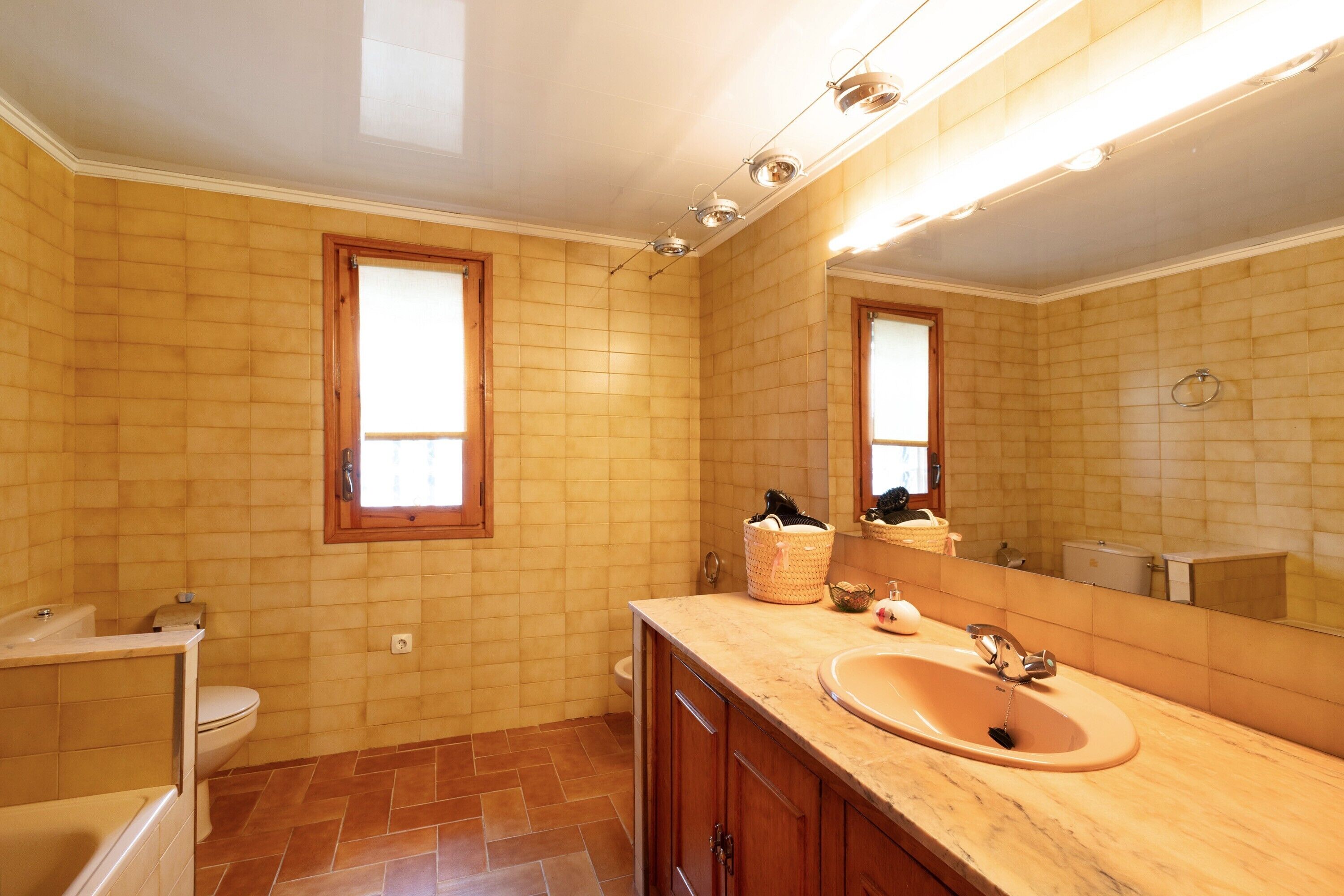 Un baño con inodoro, lavabo y espejo.