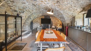 Ein Essbereich mit Stehwänden, einem Holztisch, Metallstühlen und einer modernen Pendelleuchte.