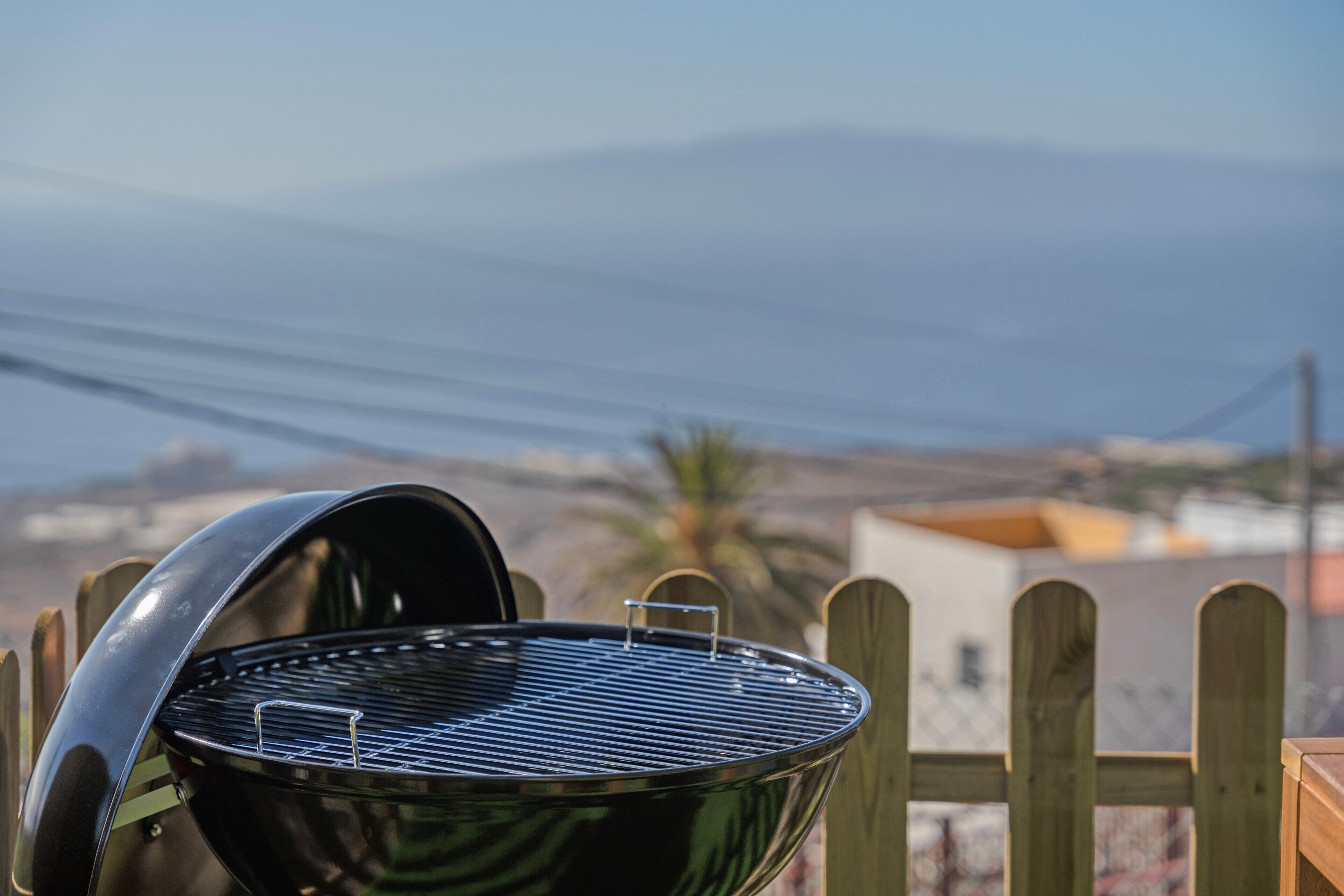 Un barbecue avec vue sur la mer et les montagnes en arrière-plan.