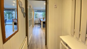 A hallway with a wooden-framed mirror, a white radiator, and a white countertop with a sink. - Verhuurburo Callantsoog - De Garnekuul 4 (Callantsoog)