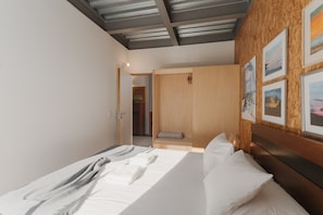 Una habitación de hotel moderna con una cama, un cabecero de madera y obras de arte en las paredes.