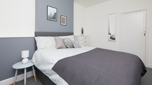 Un dormitorio con cama, mesita de noche y cómoda.