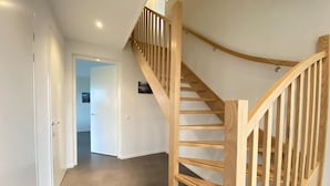 A wooden staircase with a curved design leading to a second floor.