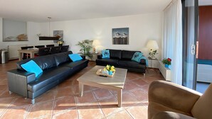 Uma sala de estar moderna com um sofá, uma mesa de centro e um espaço de jantar.
