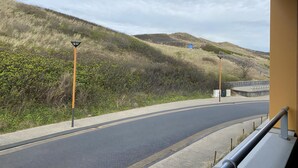 Una strada tortuosa che si snoda attraverso un paesaggio collinare, con lampioni e un guardrail.