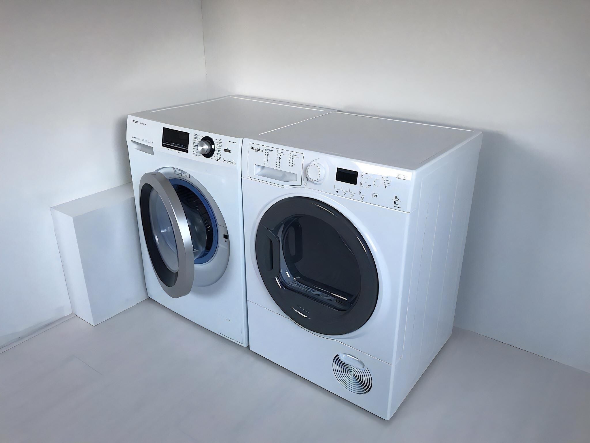 Una lavadora compacta y moderna con pantalla digital y panel de control, ubicada en un espacio minimalista con una pared lisa y un pequeño bloque blanco.