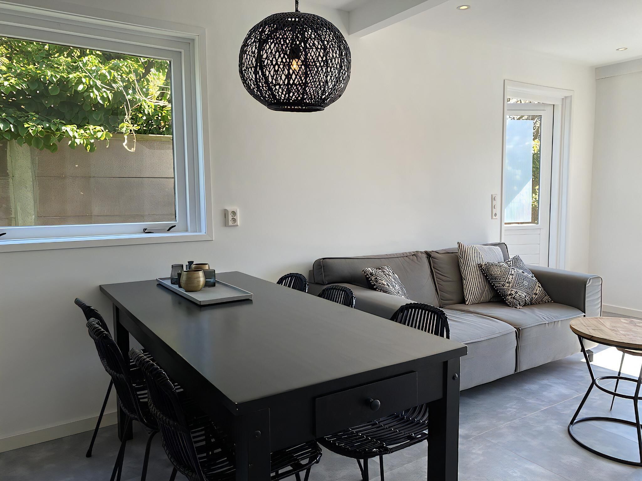 Un espace de vie moderne comprenant un coin repas, un canapé et une table ronde.