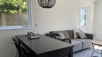 Un espace de vie moderne comprenant un coin repas, un canapé et une table ronde.