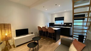 Un appartement moderne comprenant un salon, un coin repas et une cuisine.