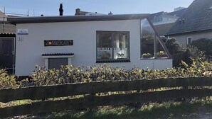A white building with a sign reading "Zonnekant" and a large window. - 2 bedroom accommodation in Callantsoog (Callantsoog)