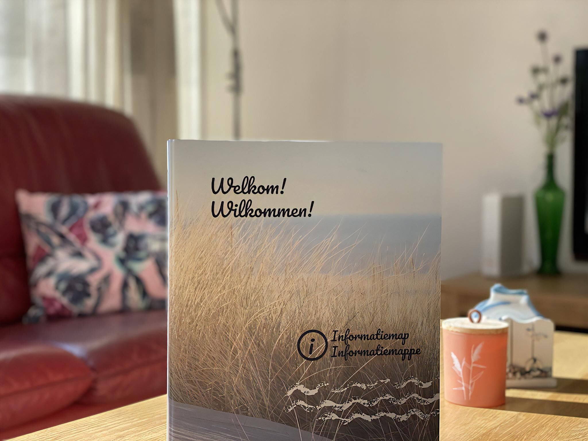 Une carte de bienvenue avec un paysage en arrière-plan, posée sur une table en bois.