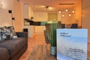 A modern living room with a sofa, a coffee table, and a potted plant. - Callantsoger Staete A03 (Callantsoog)