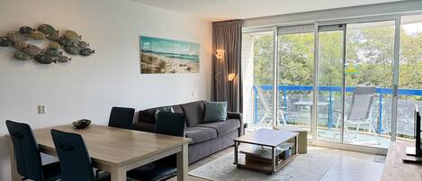 A modern living room with a dining area, a sofa, and a coffee table.