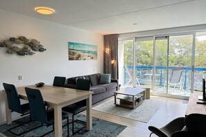 A modern living room with a dining area, a sofa, and a coffee table.