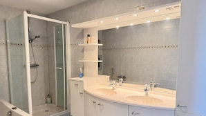 A modern bathroom with a glass-enclosed shower, two sinks, and a large mirror. - Callantsoger Staete A210 (Callantsoog)