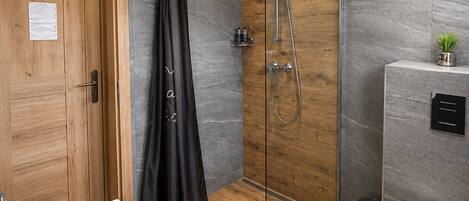 A modern bathroom with a shower, toilet, and sink.