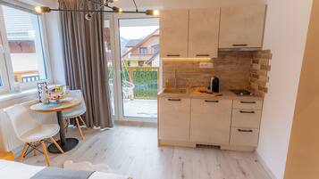 Een compacte keuken met een eethoek, een groot raam en uitzicht op de omgeving.