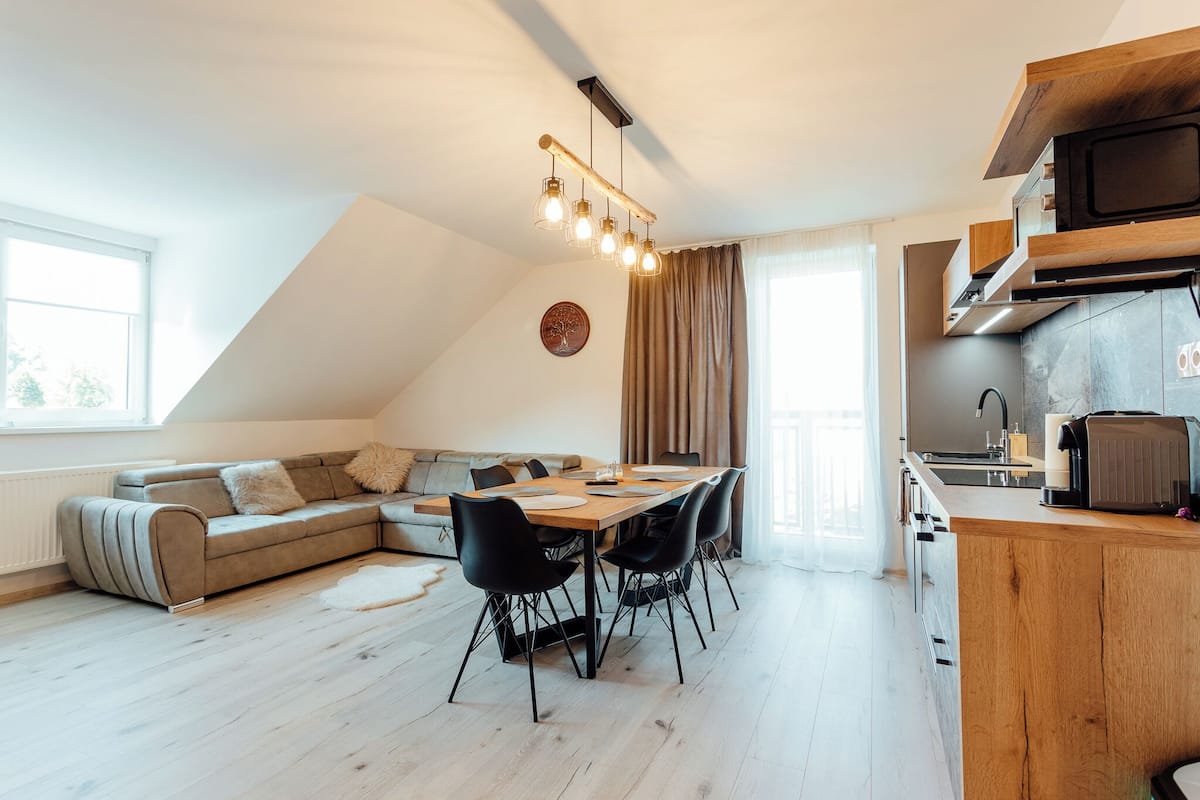 A modern kitchen with a wooden countertop, a built-in microwave, and a stove.
