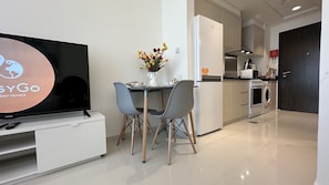 Enjoy meals in this well-equipped kitchen and dining area, featuring a flat-screen TV and comfortable seating for two.