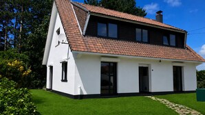 A single-story house with a sloped roof, a front entrance, and a visible chimney. - Near Le Touquet, renovated villa for a relaxing break with family or friends. (Cucq)