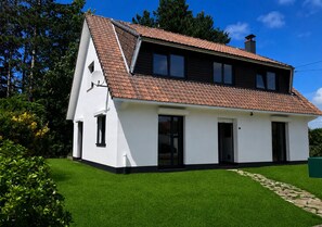 Una casa a un piano con tetto spiovente, un ingresso principale e un camino ben visibile.
