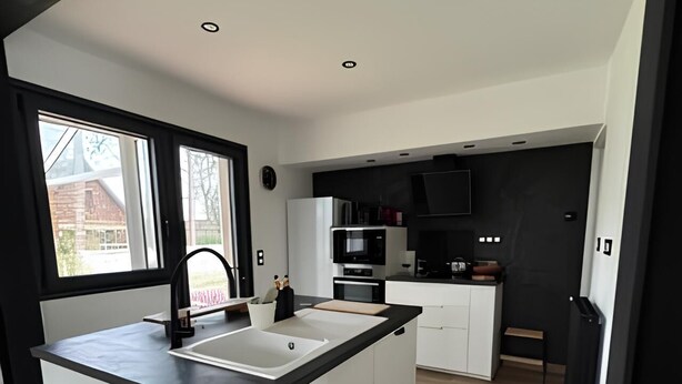 A modern kitchen with a central island, white cabinetry, and a black countertop. - Near Le Touquet, renovated villa for a relaxing break with family or friends. (Cucq)