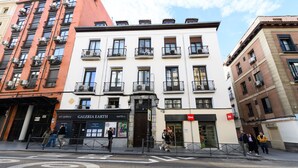 Um edifício com vários andares, que inclui uma galeria de arte no andar térreo e uma entrada visível.