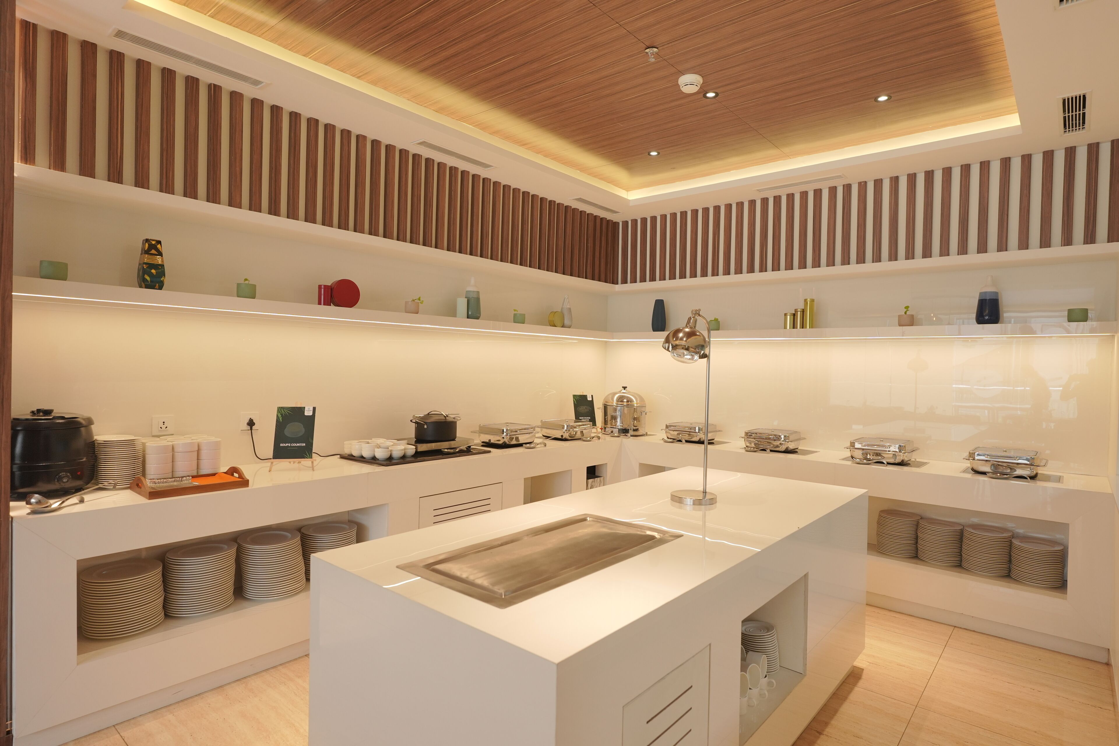 A modern kitchen with white cabinetry, stainless steel appliances, and a central island with a sink.