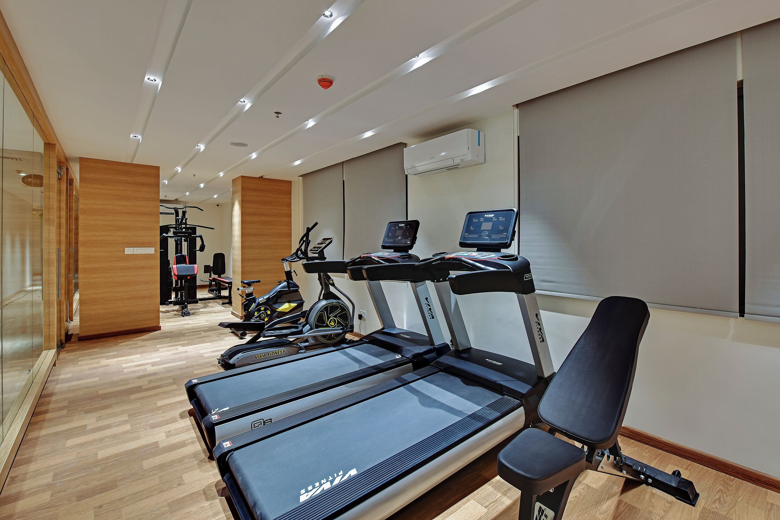 A modern gym with treadmills, stationary bikes, and a rowing machine.