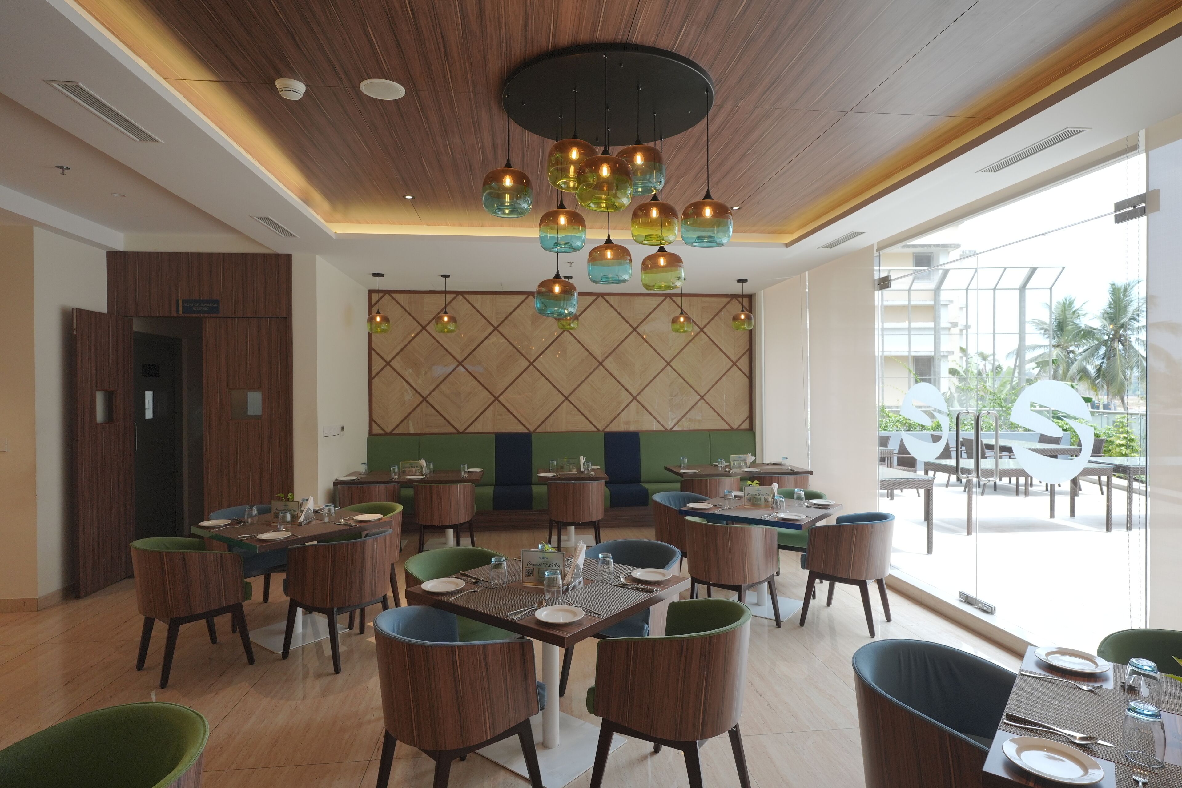 Een restaurant met meerdere tafels en stoelen, een houten plafond en uitzicht op het omliggende landschap.
