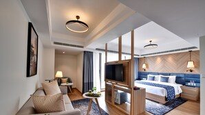 A modern hotel room with a sofa, TV, bed, and a small table with snacks. - Clarion Hotel Khayal Kochi, Infopark (Kanayannur)