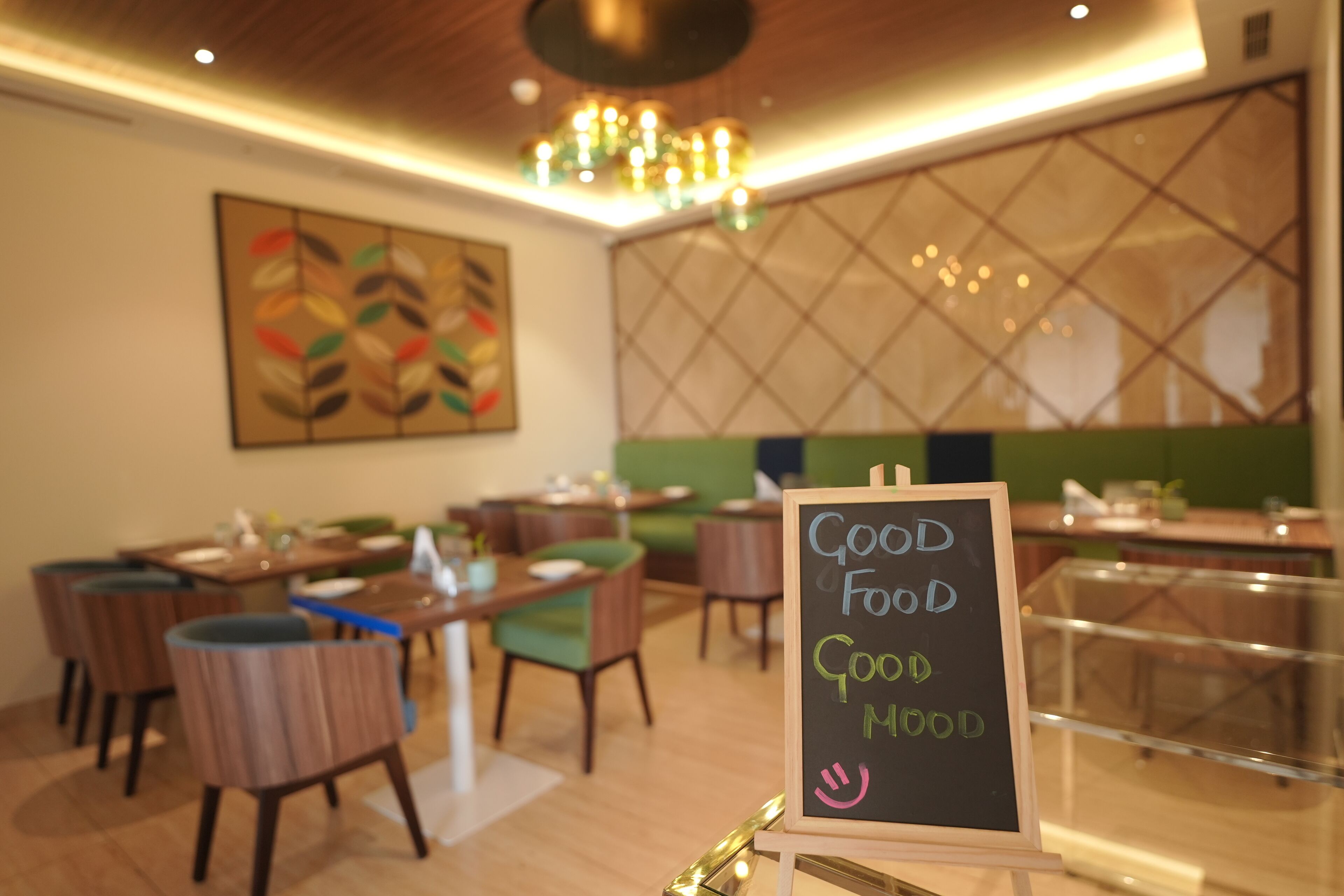 A restaurant interior with a chalkboard sign reading "GOOD FOOD GOOD MOOD".