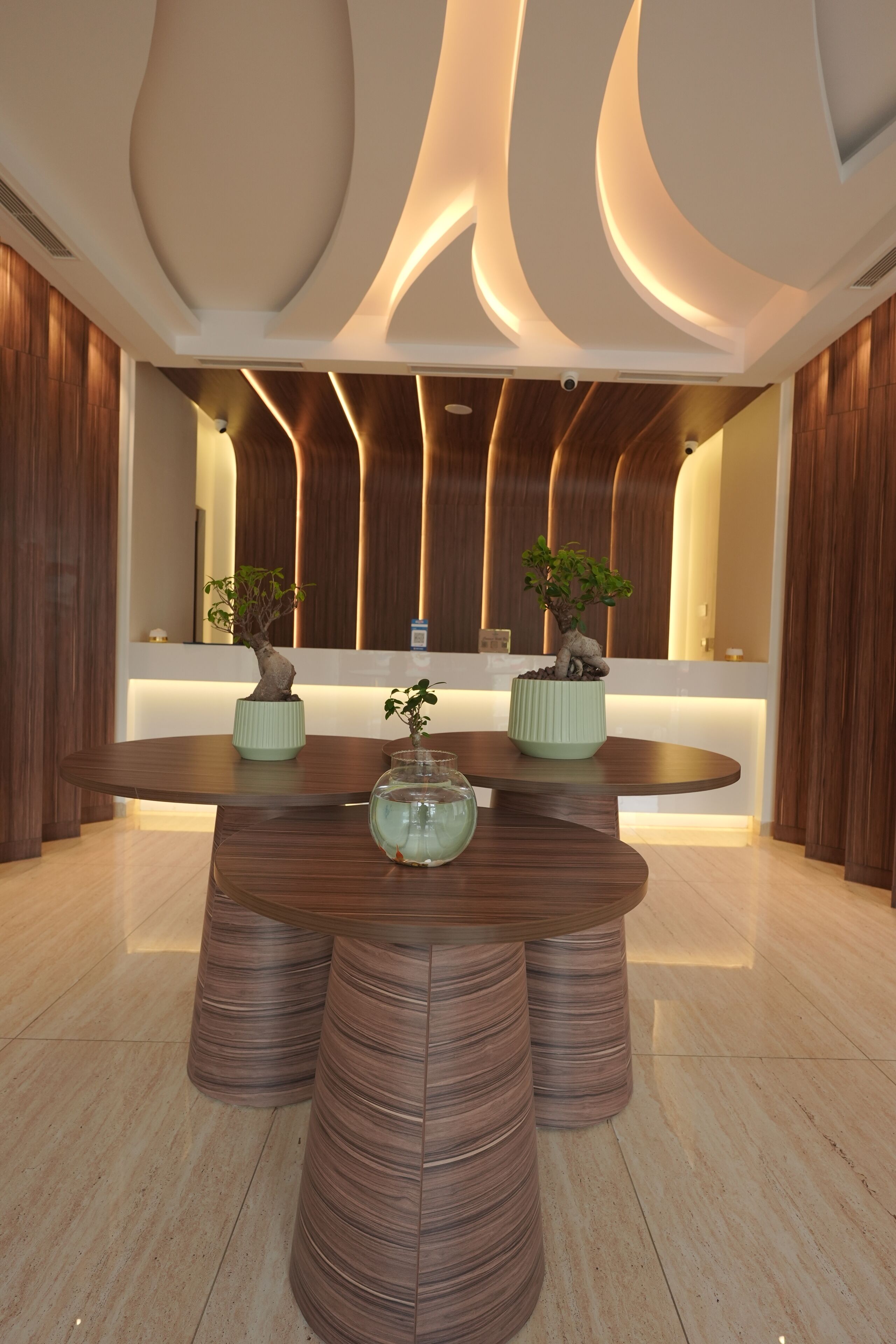 Un espace repas moderne avec une table ronde, des éléments décoratifs en bois et des plantes en pot.