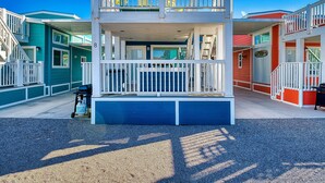 A two-story building with a balcony, a covered entrance, and a small outdoor area with a grill. - Bubbles and Brews, Premium Views at Roadrunner Resort (Parker)