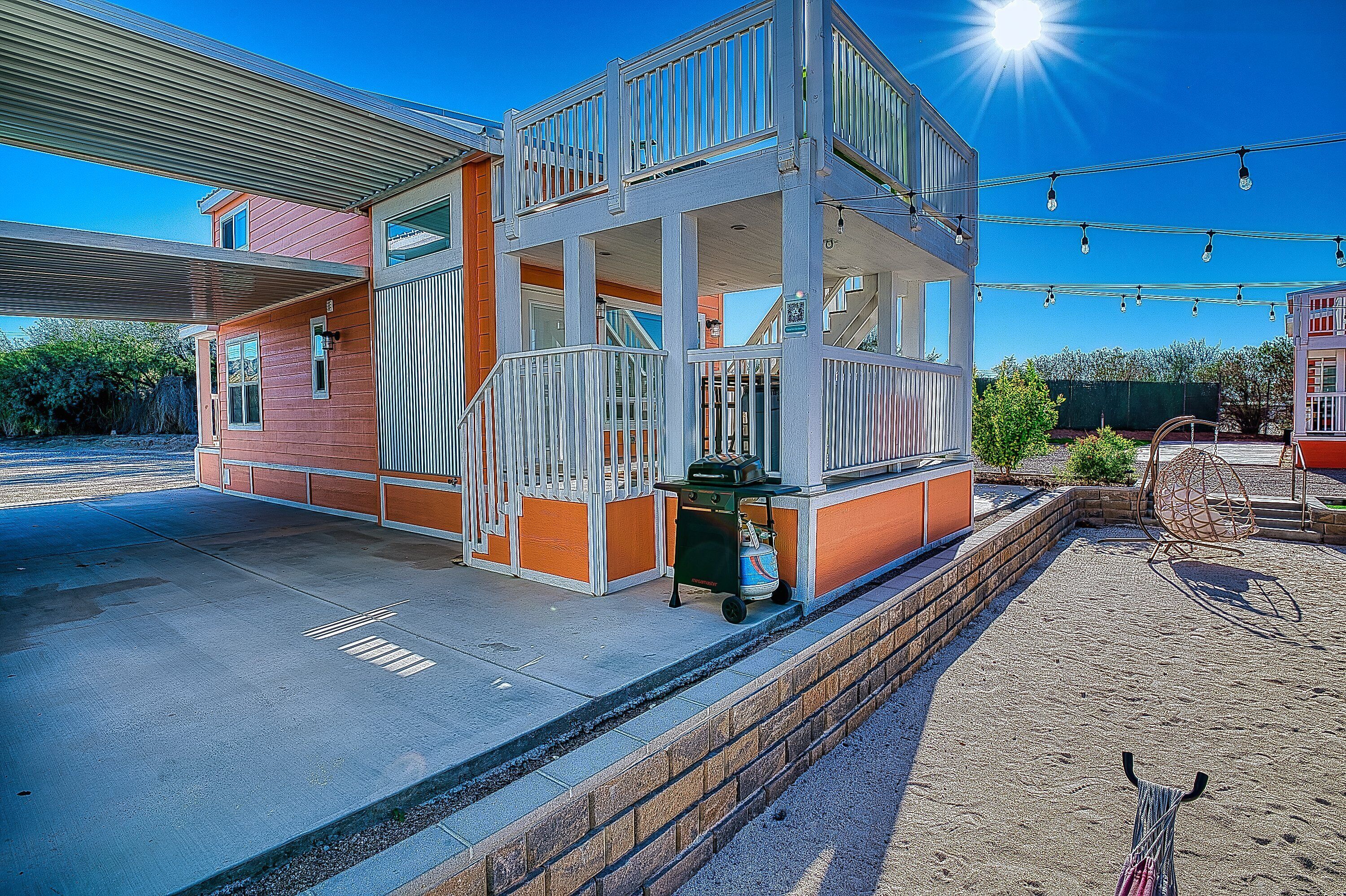 A multi-story building with balconies, a barbecue area, and outdoor seating.