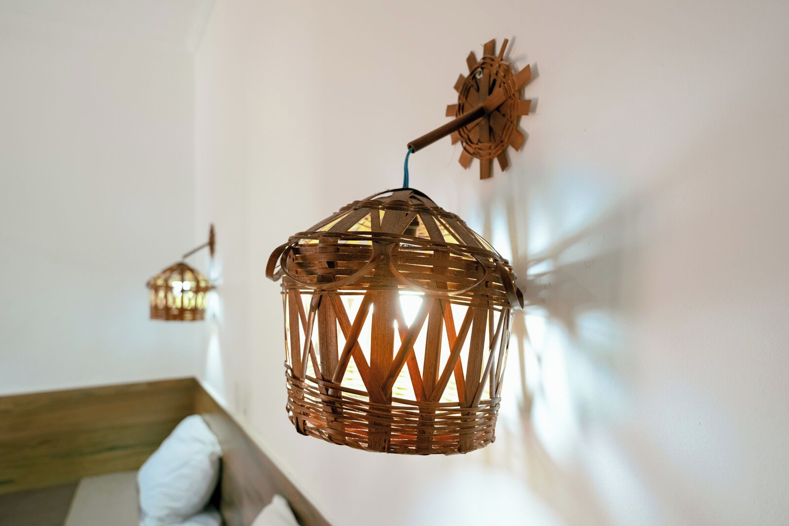 A room with a hanging wicker lamp and a wall-mounted clock.