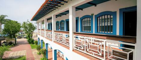 A building with a covered walkway, white and blue exterior, and a tiled roof.
