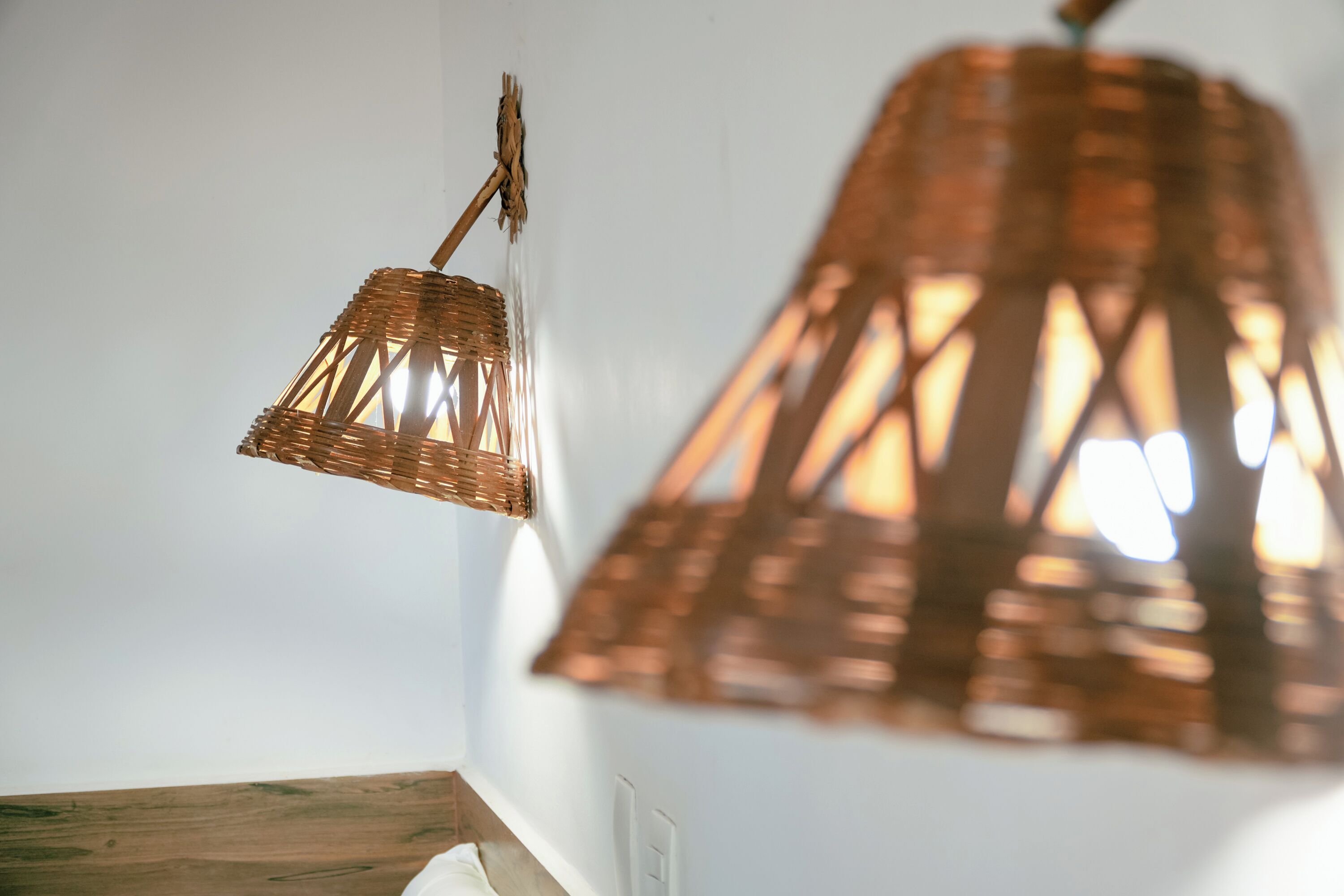 A close-up of a woven, copper-colored pendant light fixture.