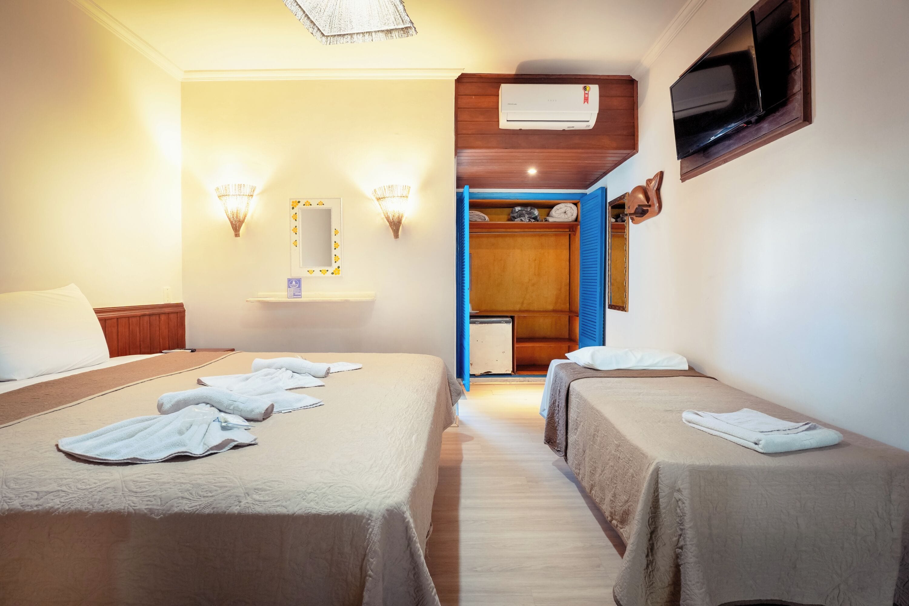 A hotel room with two beds, a TV, and a small desk.