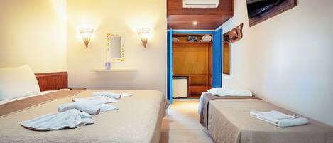 A hotel room with two beds, a TV, and a small desk.
